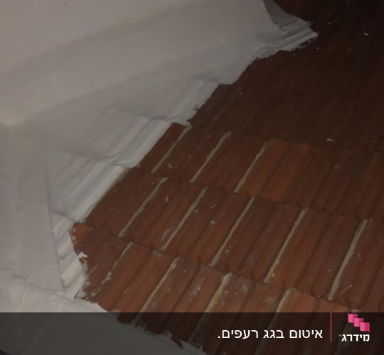 איטום גג עם חומר לבן על רעפים חומים